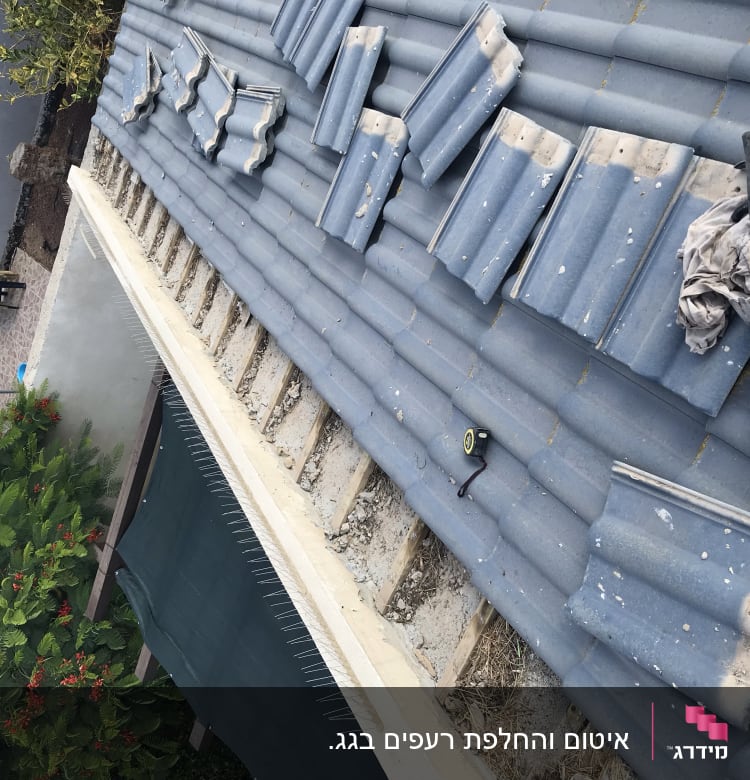 רעפים מונחים על גג עם כלי עבודה וחומרי איטום